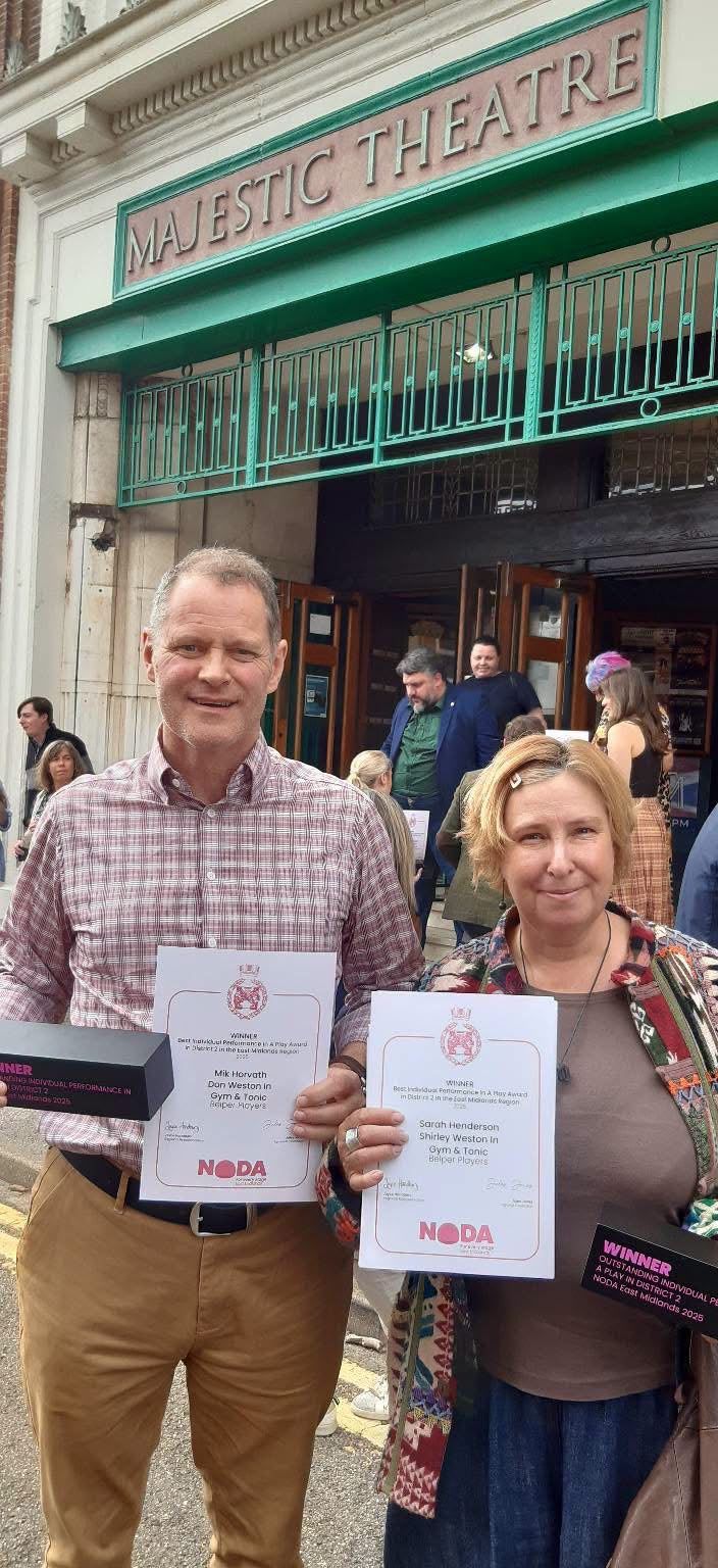 Mik Horvath and Sarah Henderson outside the Majestic Theatre, each holding a NODA winner's certificate for Gym and Tonic